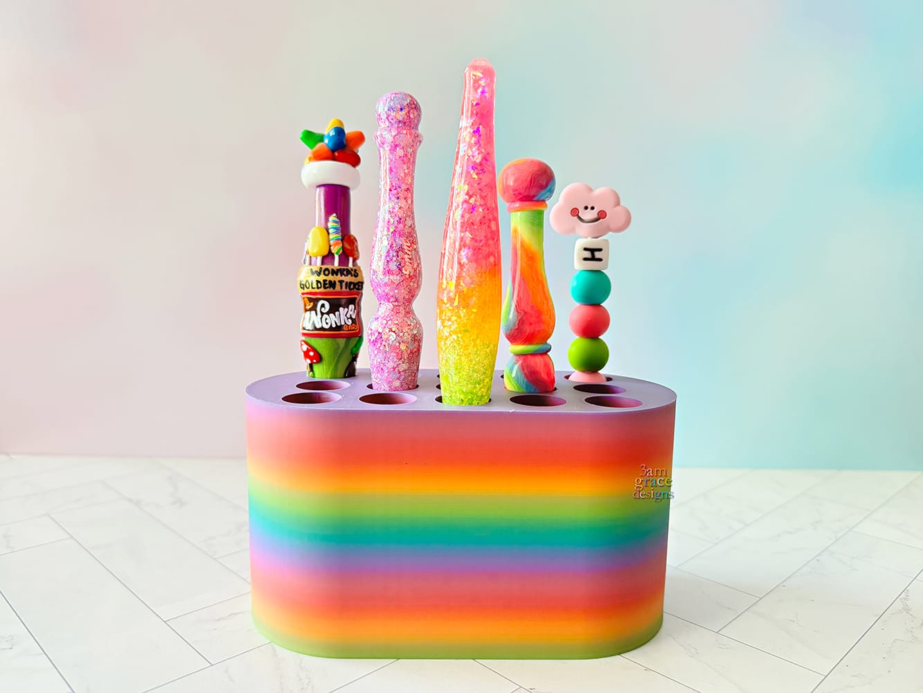 rainbow colored crochet hook stand with colorful crochet hooks on a blue background
