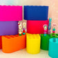 Colorful crochet hook stands with crochet hooks on a light wooden surface.