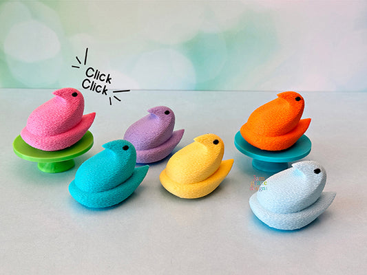 Colorful Chick Peep fidget clickers on a white background.
