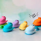Colorful Chick peep shaped fidget clickers on stands with a pastel gradient background.