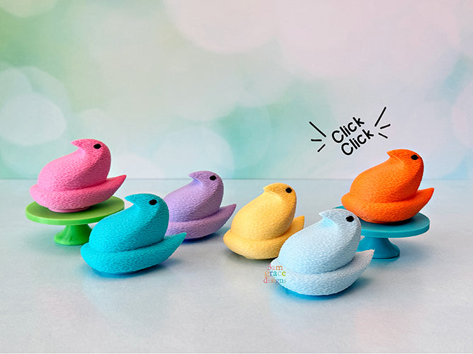 Colorful Chick peep shaped fidget clickers on stands with a pastel gradient background.