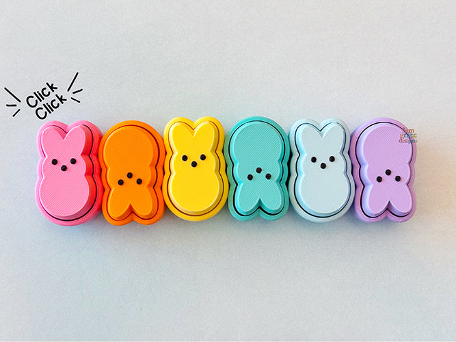 Colorful peep-shaped fidget clickers on a white background 