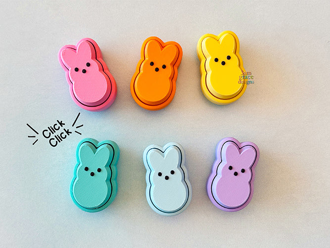 Set of colorful peep-shaped fidget clicker on a light background