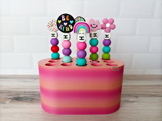 Colorful crochet hook stand with beaded crochet hooks on a wooden surface