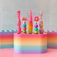 Colorful crochet hook holder with various crochet hooks on a tiled wall background