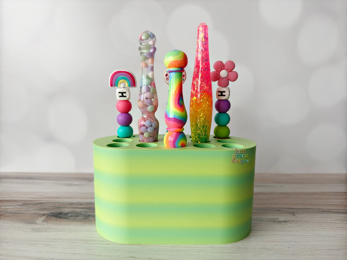 colorful crochet hooks on a green crochet hook stand against a plain background