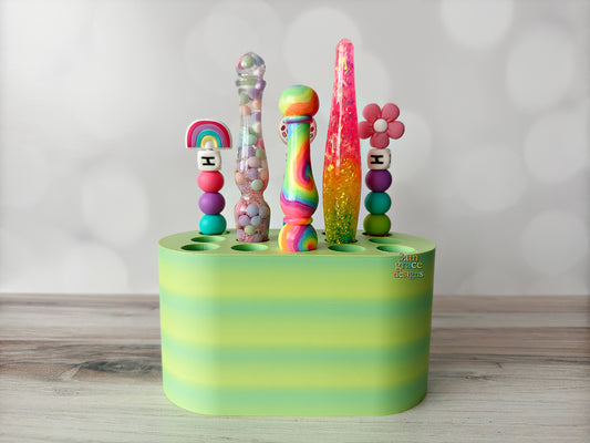 colorful crochet hooks on a green crochet hook stand against a plain background