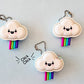 three white cloud fidget clickers with kawaii faces on blue background