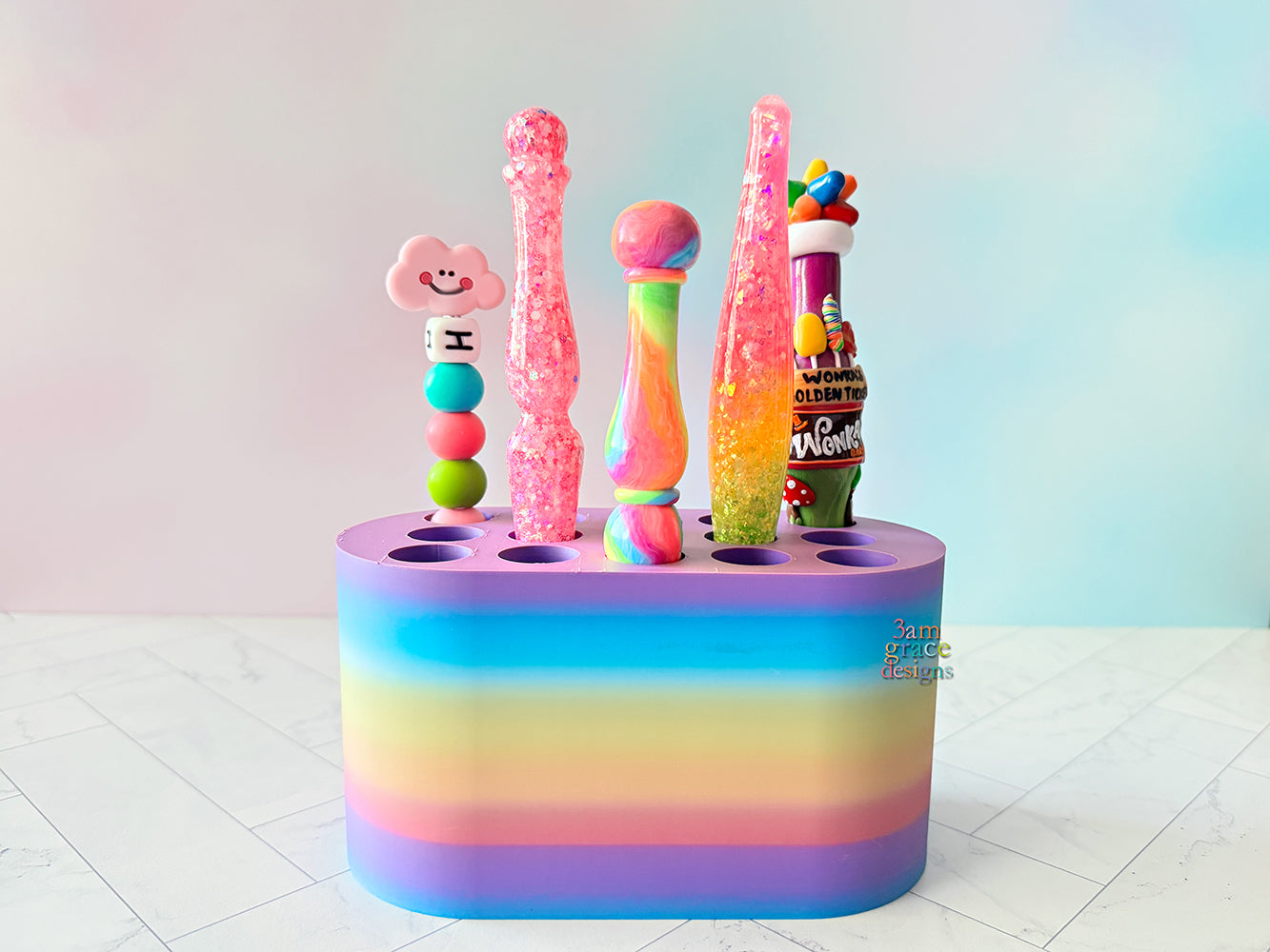 Colorful crochet hook stand with various colorful crochet hooks on a white floor and light blue wall background