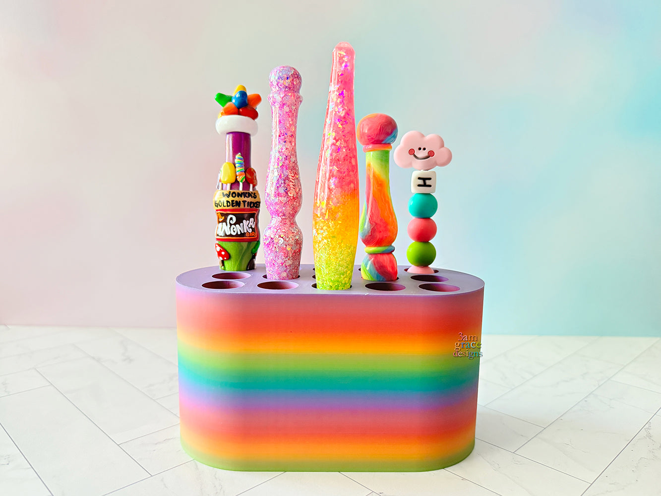 rainbow colored crochet hook stand with colorful crochet hooks on a blue background
